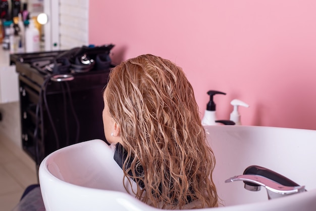 Lavagem de shampoo de cabelo loiro feminino