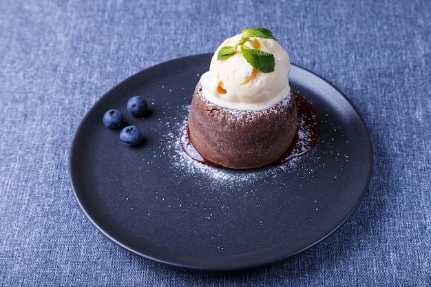 Lavakuchen Schokoladenfondantkuchen mit Vanilleeis Blaubeeren und Minze Nahaufnahme