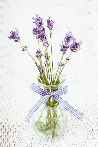 Foto lavanda em garrafa, decoração estilo provance em toalha de mesa de crochê, chique surrado