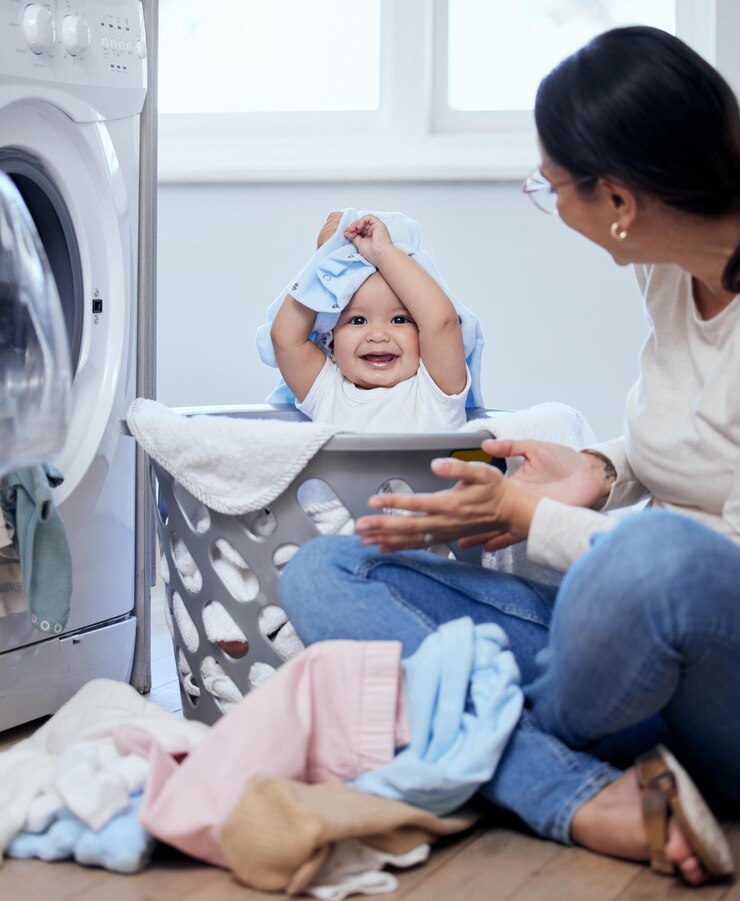 Foto lavanderia mãe e bebê na cesta com diversão ligação e desenvolvimento da criança com criança feliz em casa limpeza da casa mãe e menina bebê brincando juntos com roupas máquina de lavar e limpeza