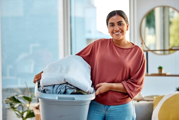 Lavandería de mujer y sonrisa de retrato para ropa limpia higiene personal o tareas domésticas en casa Mujer feliz sosteniendo cesta de lavado de material para tareas de limpieza o limpieza en la sala de estar
