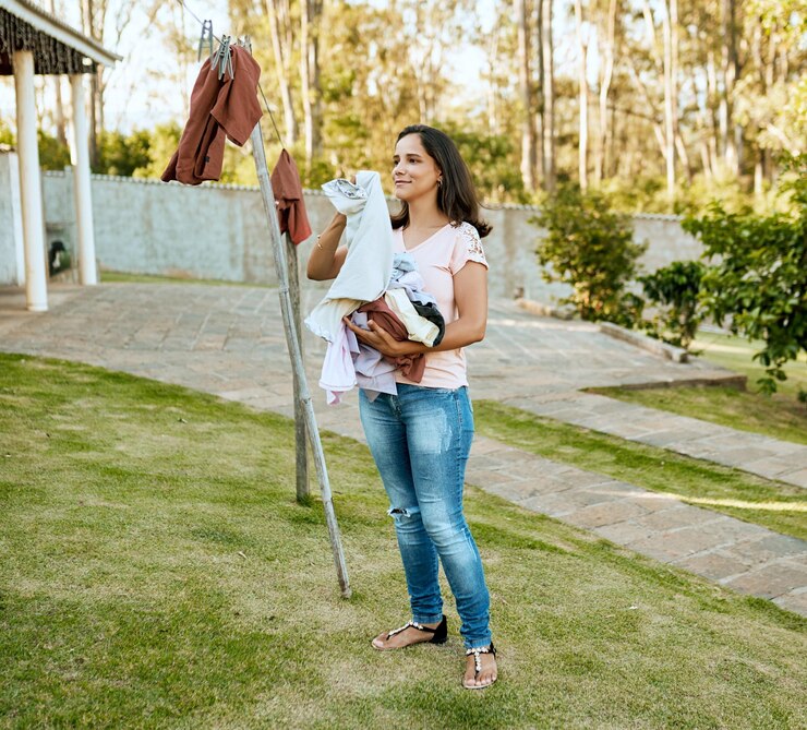 Foto lavanderia mulher e roupas linha ao ar livre para secar higiene ou tarefas domésticas na natureza tarefas pendurando roupas e pessoa no quintal para limpeza de primavera lavar tecido e algodão fresco em corda no verão