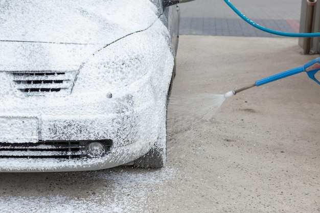 Lavando o carro com espuma em uma pia de autoatendimento