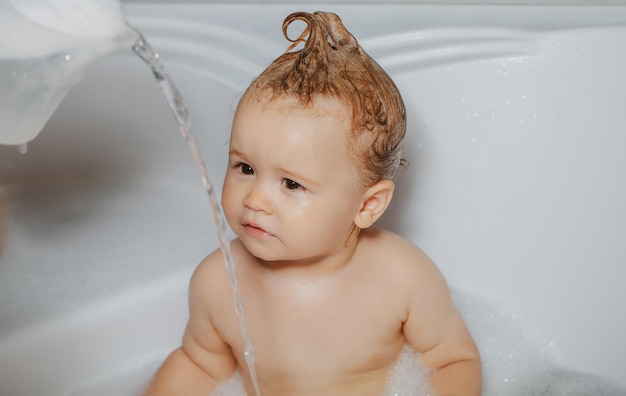 Lavando um bebê adorável no banheiro com espuma de sabão no cabelo tomando banho retrato aproximado de sorrir