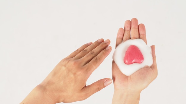 Lavar as mãos com espuma e sabão rosa em fundo branco Foto de estúdio