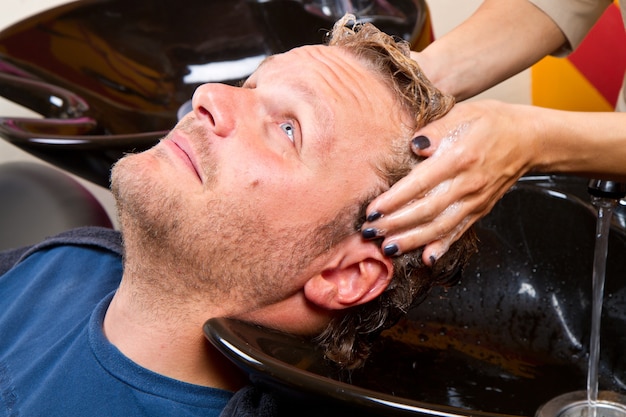 Lavar el cabello de hombre en salón de belleza peluquería