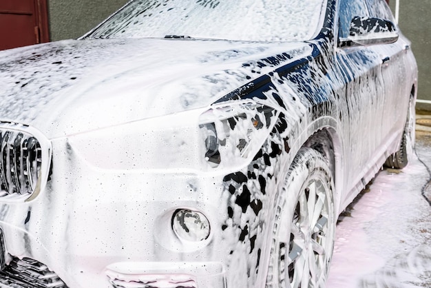 Foto lavar carro preto usando lavagem de alta pressão e shampoo de carro