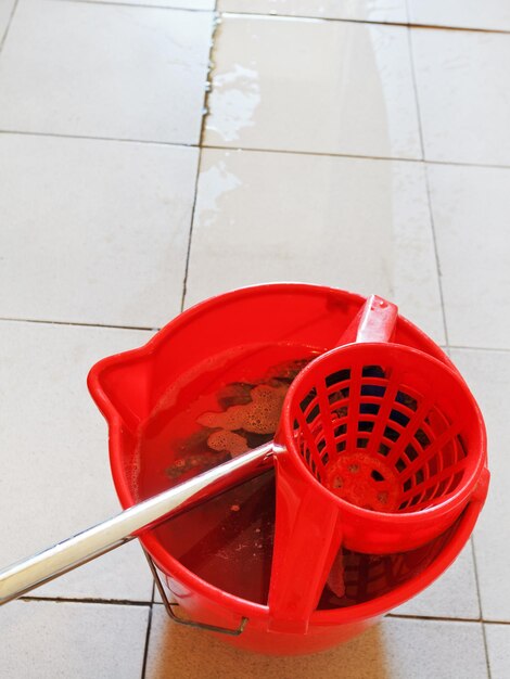 Lavar el suelo de baldosas con un trapeador