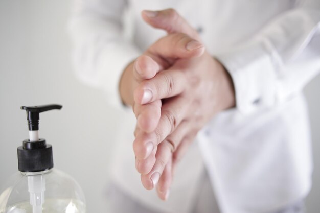 Foto lavarse las manos con desinfectantes de alcohol o gel de alcohol de la botella de la bomba concepto de higiene y cuidado de la salud