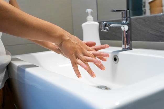 Lavarse las manos frotando con jabón mujer