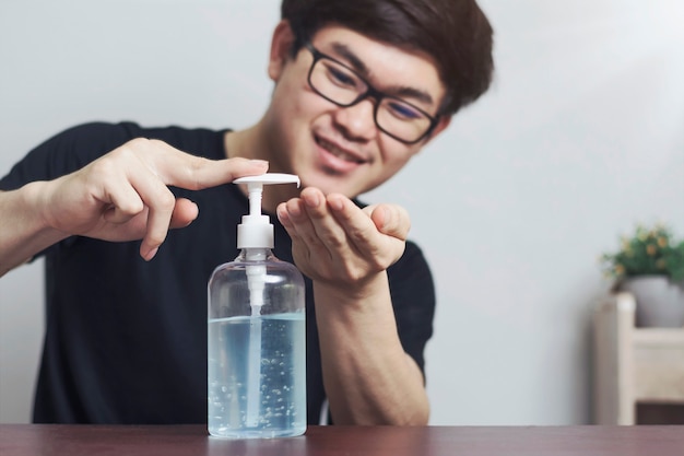 Lavarse las manos en gel desinfectante con un joven asiático para la prevención del virus corona