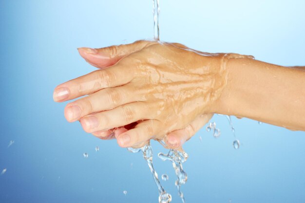 Lavarse las manos en primer plano de fondo azul