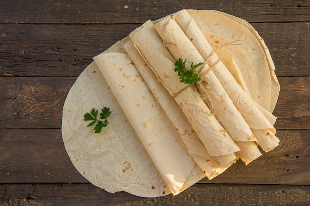 Lavash pan plano armenio. Pan Pita en tabla de cortar de madera. Copia espacio