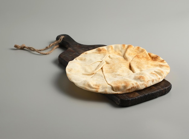 Lavash de pan plano tradicional sobre un fondo gris de tablero de madera