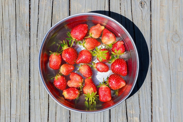 Lave las fresas maduras y jugosas en un tazón