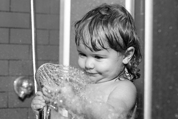 Lave la higiene infantil y el cuidado de la salud lavando a un bebé adorable en el baño para niños con espuma de jabón en el cabello