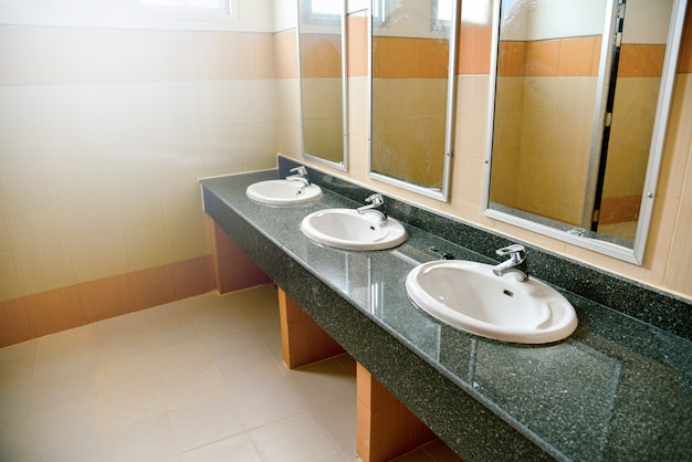Foto lave el lavabo y los espejos del lavabo blanco en el baño público