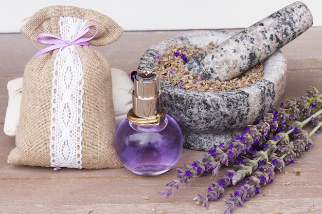 Lavendel Kräuterwasser in einer Glasflasche mit frischen und trockenen Blumen auf dem Tisch