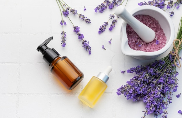 Lavendel-Spa Lavendelsalz, natürliches ätherisches Öl und frischer Lavendel auf weißem Fliesenhintergrund