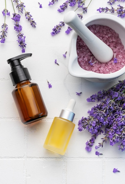 Lavendel-Spa Lavendelsalz, natürliches ätherisches Öl und frischer Lavendel auf weißem Fliesenhintergrund