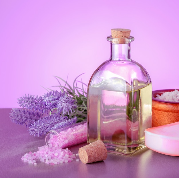 Lavendel-Spa-Produkte mit natürlichem Öl, Seife, Meersalz und Lavendelblüten auf dem Tisch.