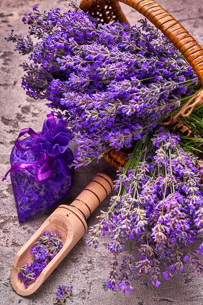 Lavendelblüten im Korb und im aromatischen Beutel auf grauem Beton. Draufsicht.