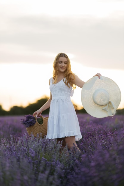 Lavendelfeld sexy Mädchenportrait in Strohhut Provence Frankreich Ein Mädchen im weißen Kleid zu Fuß durch Lavendelfelder bei Sonnenuntergang