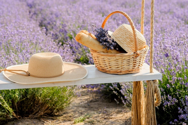 Lavendelfeld Strohhut und Picknickkorb auf einer Schaukel ein Symbol für Sommerferien