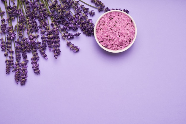 Lavender SPA. Flores de lavanda e sal de banho em uma tigela sobre fundo roxo. Copie o espaço, vista superior. SPA