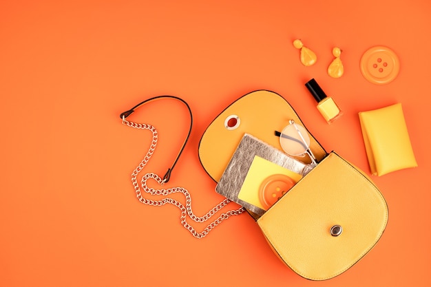 Lay Flat con accesorios de moda de mujer en color amarillo sobre pared con textura de cuero naranja. Moda, blog de belleza online, estilo de verano, concepto de compras y tendencias.