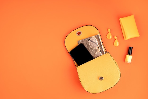 Lay Flat con accesorios de moda de mujer en color amarillo sobre pared con textura de cuero naranja. Moda, blog de belleza online, estilo de verano, concepto de compras y tendencias.