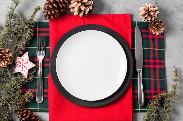 Foto lay flat de arreglo de mesa de navidad con plato y cubiertos