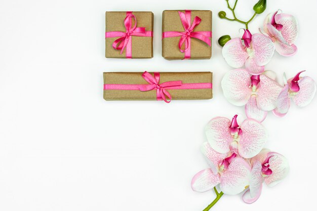 Lay Flat de cajas presentes con cinta rosa y flores de orquídeas