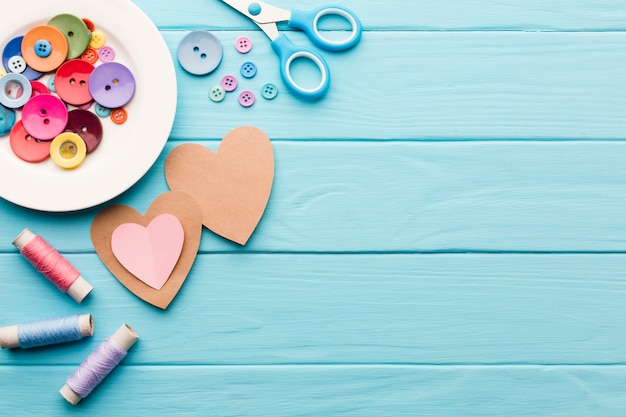 Foto lay flat de corazones de papel para el día de san valentín con suministros de costura