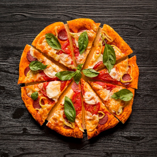 Foto lay flat del delicioso concepto de pizza en mesa de madera