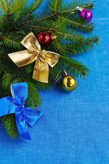 Lay Flat de Navidad. Rama de abeto decorado con adornos de colores sobre una servilleta azul.