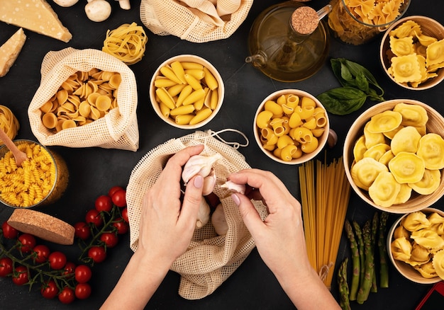 Lay Flat con pasta italiana orgánica tradicional e ingredientes de cocina en bolsas de algodón reutilizables y recipientes de vidrio. Cero desperdicio, concepto libre de plástico