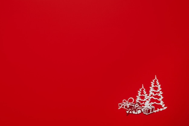 Layout auf rotem Hintergrund mit einem schönen weißen Weihnachtsbaum und Geschenken. Frohe Weihnachten Konzept