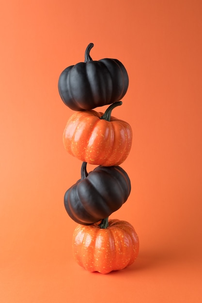 Layout criativo de abóboras pretas e de outono com fundo laranja