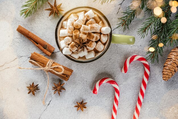 Layout criativo de feriado de Natal com chocolate quente de marshmallow, galhos de árvores de abeto e pinhas