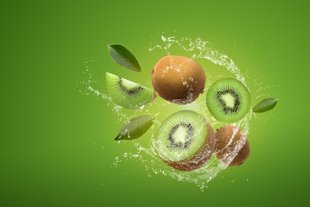 Foto layout criativo feito de fatias de kiwi e salpicos de água sobre um fundo verde