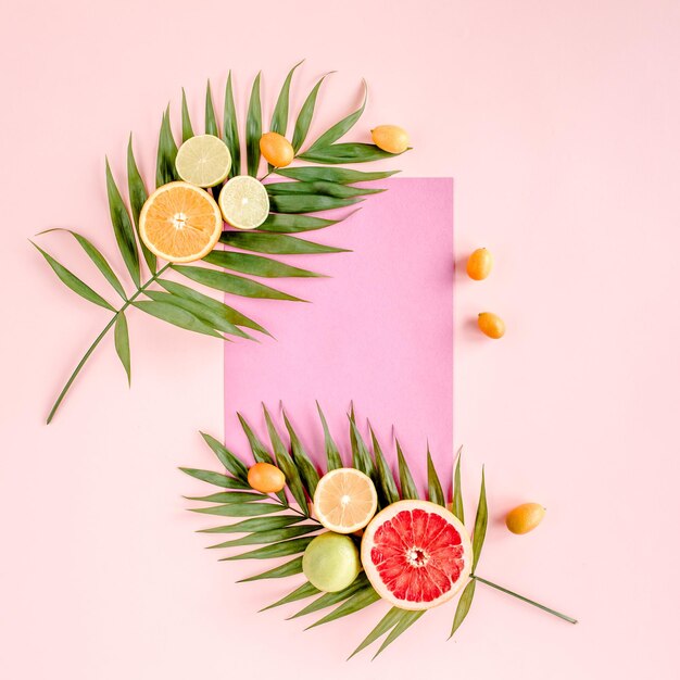 Layout criativo feito de papel e frutas tropicais de verão no conceito de comida de fundo rosa plano para