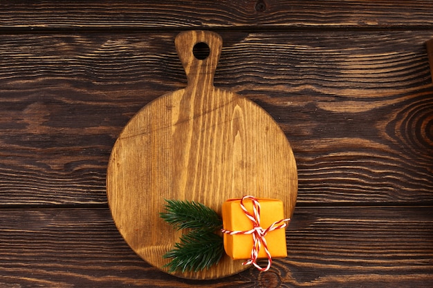 Foto layout de culinária de natal em um fundo de madeira. tábua de corte de madeira com artigos de natal para o menu da mesa do feriado. vista superior, estilo plano.