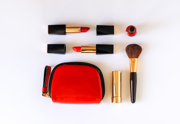 Layout plano de productos cosméticos de belleza en color rojo, negro y dorado amontonado