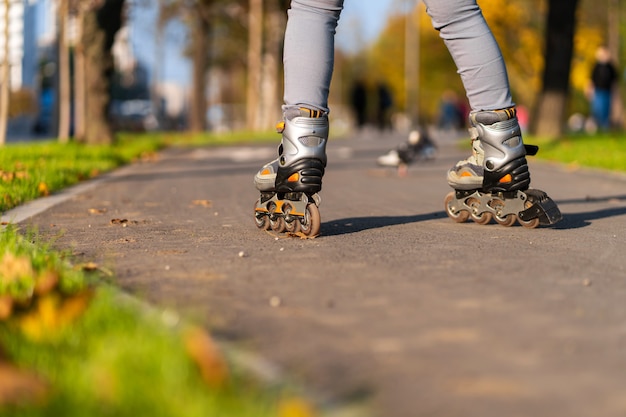 Lazer ativo. uma garota esportiva está patinando em um parque de outono.