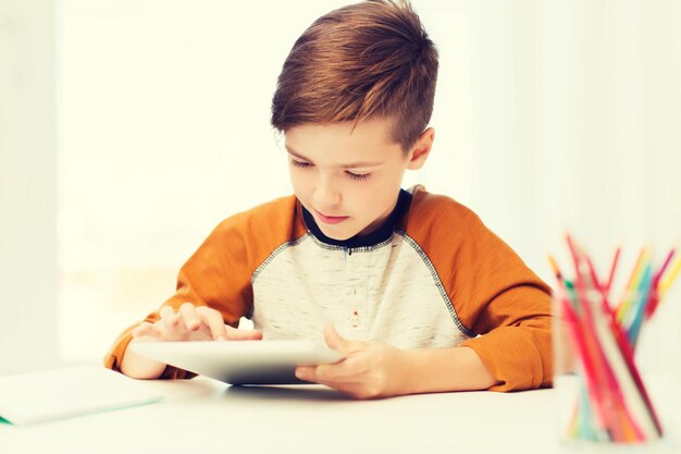 lazer, crianças, tecnologia e conceito de pessoas - close-up do menino com computador tablet pc em casa