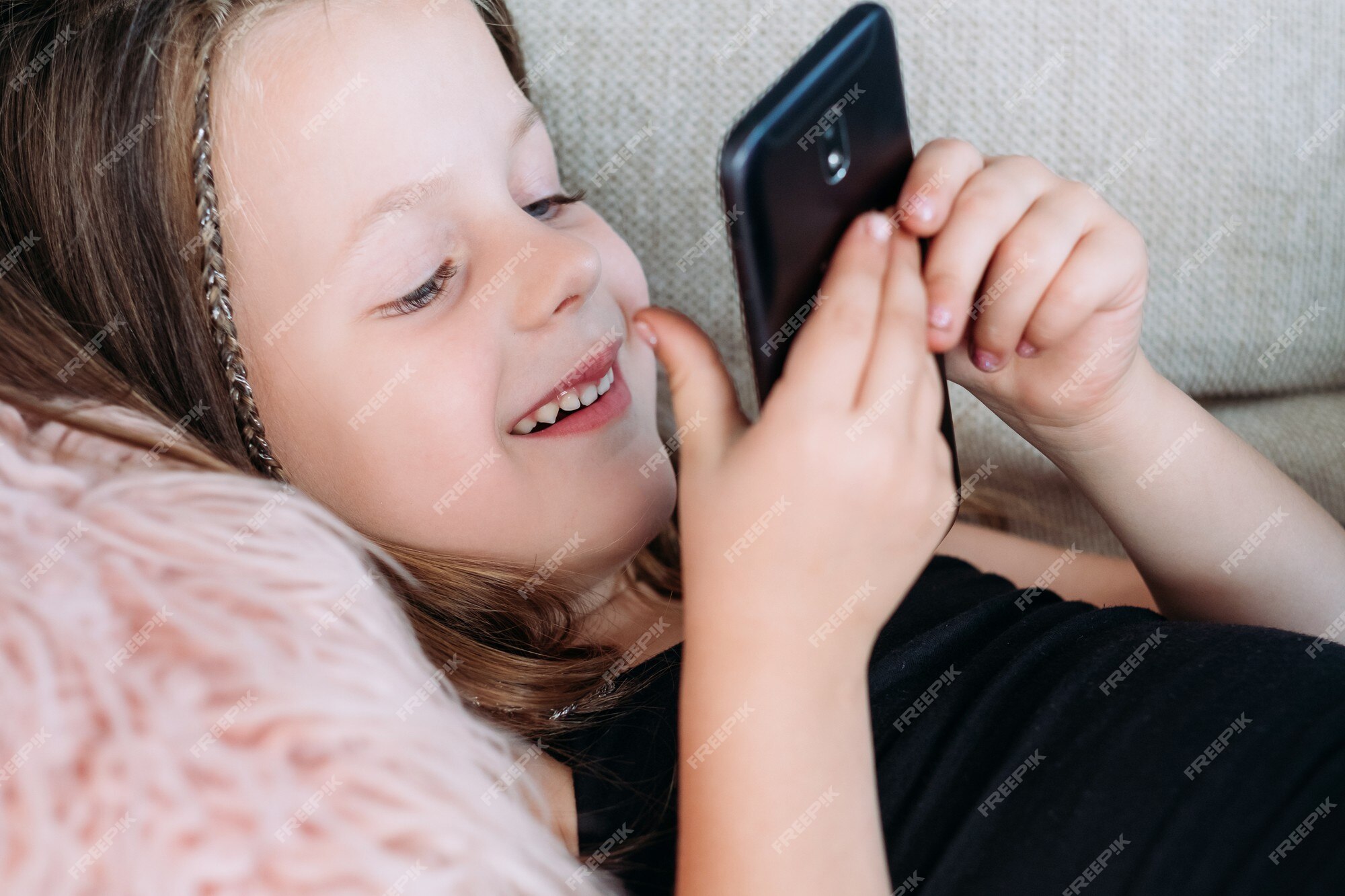 Lazer e entretenimento infantil. tecnologia e dispositivos digitais na  educação de crianças. garota feliz e sorridente jogando jogos no celular.