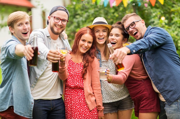 lazer, férias, pessoas, reunião e conceito de celebração - amigos felizes com bebidas na festa no jardim de verão