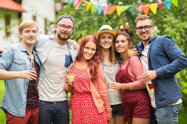 lazer, férias, pessoas, reunião e conceito de celebração - amigos felizes com bebidas na festa no jardim de verão