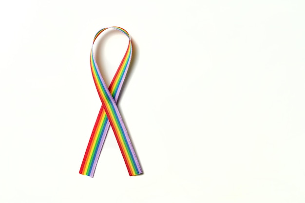 Lazo de cinta de color del arco iris en apoyo de la comunidad LGBTQ sobre un fondo blanco